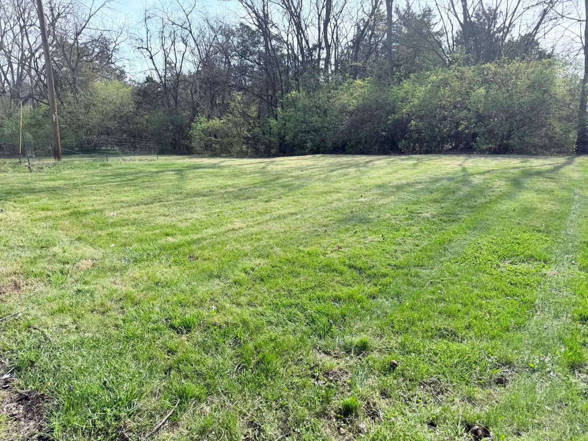 Professional lawn mowing on large open lot in Winchester VA